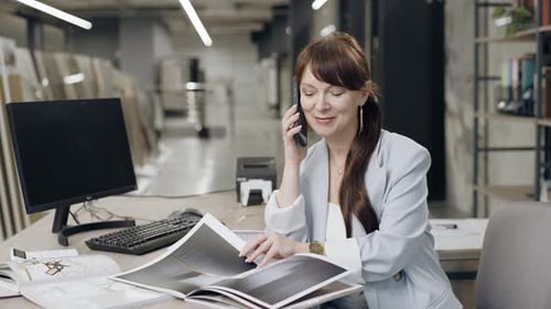 Woman talking on cell phone at office desk