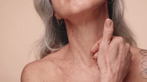 Senior Woman Stroking Her Neck Close Up