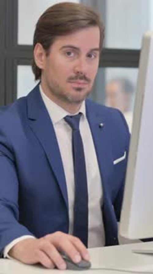 Man Smiling While Working at Office Computer