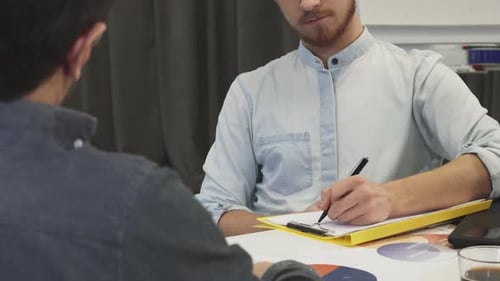 Homme d'affaires concentré prenant des notes avec attention lors d'une réunion dynamique