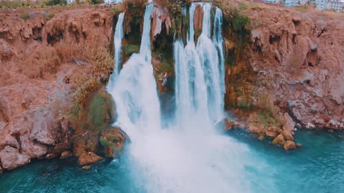 Aerial Drone Video Footage of a Waterfall Falling Off a Cliff Into a Turquoise Lagoon