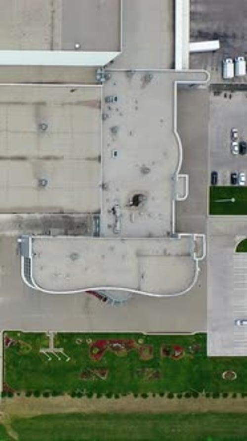 Techo gris de una planta grande. Exterior de una fábrica con plazas de aparcamiento. Industria sobre el terreno.