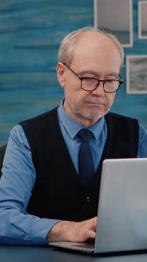 Man Working at Laptop Computer in Office
