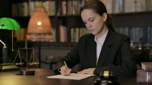 Woman Attorney Writes at Desk with Legal Symbols