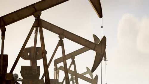 Pumpjacks Operate At An Oil Extraction Site During Sunset Hours