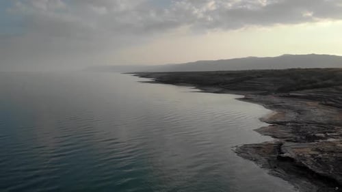 Dead Sea arid shore with sunset at dusk, aerial