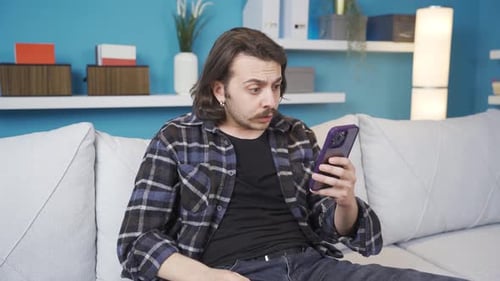Worried Man Reacts to Phone on Couch