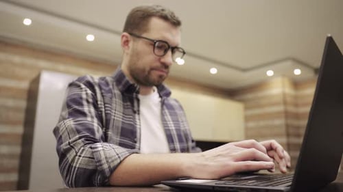 Adult Typing on Laptop in Indoor Setting