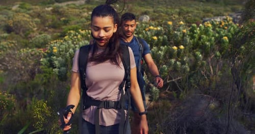 Hikers walking a trail on a mountain with hiking sticks
