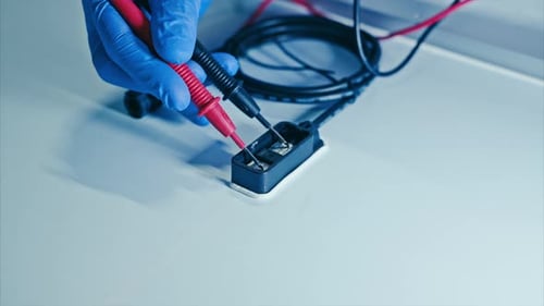 Solar Panel Manufacturing Line.
Close up view of hands in blue rubber gloves working in production