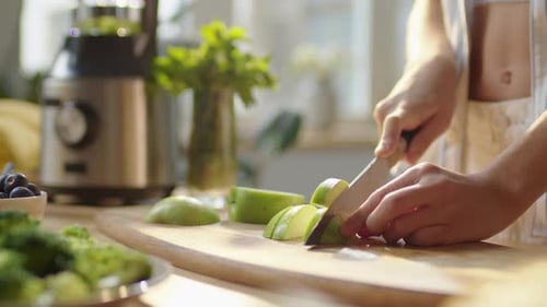 Hands of Woman Cutting Green Apple