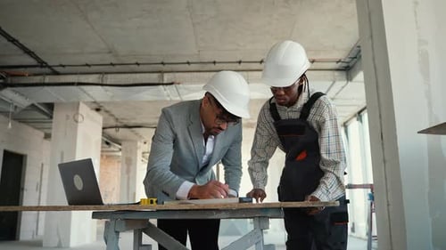 Architect and Foreman Discussing Blueprint on Construction Site