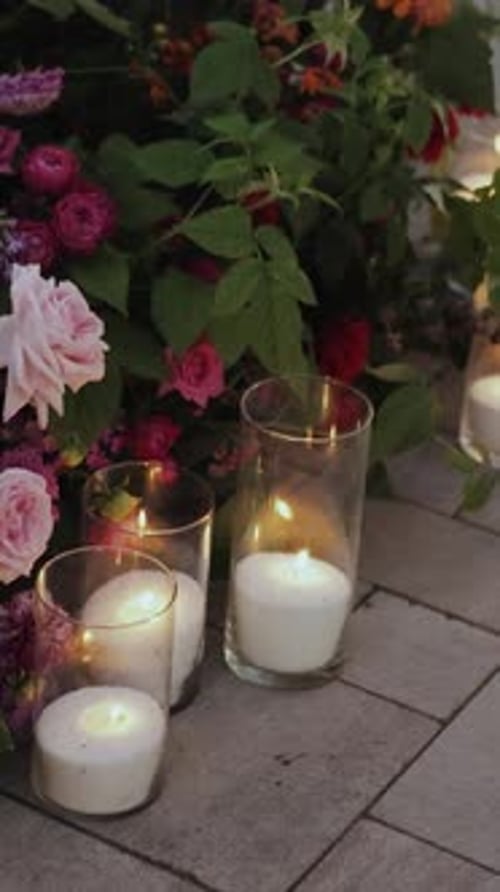 Candles Stand Next to Flowers on the Ground Creating a Carefree Atmosphere Next to the Wedding