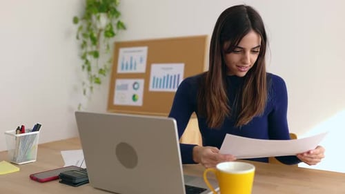 Smiling Freelance Businesswoman Working on Laptop Computer in Office