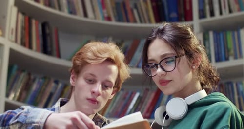 Close Up of Caucasian Young Cheerful Male and Female Students Standing Together in Library and