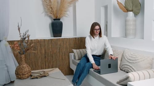 Woman Opens Laptop at Home in Bright Room