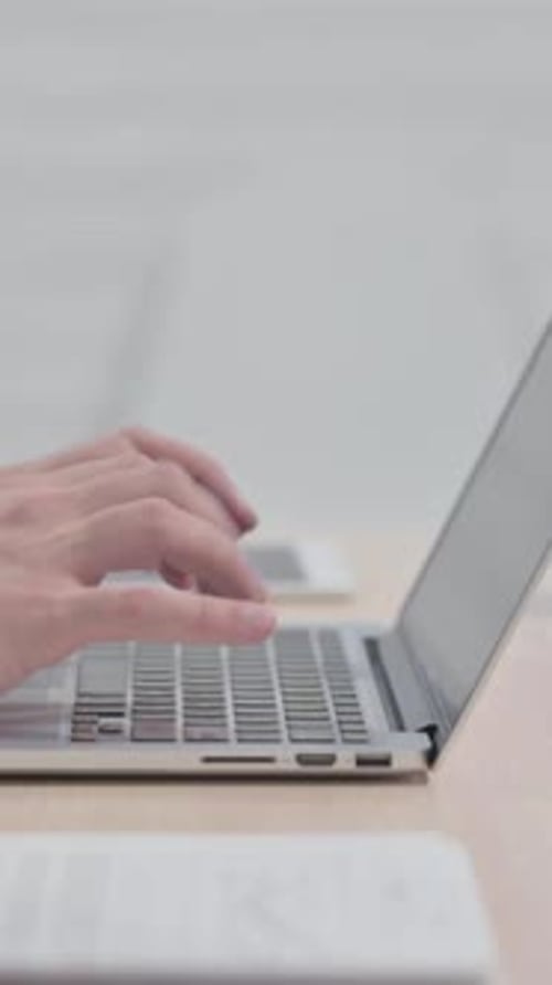 Side View of Young Man Typing on Laptop, vertical video