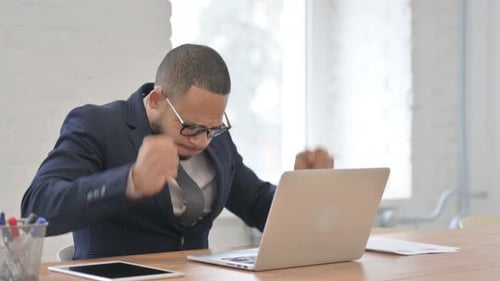 Frustrated Man Working on Laptop in Office