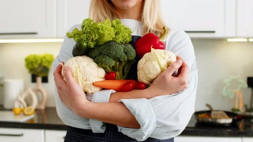 Young Woman Holding Vegetables Groceries From Store Promoting Keto Healthy Easy Nutrition in Kitchen