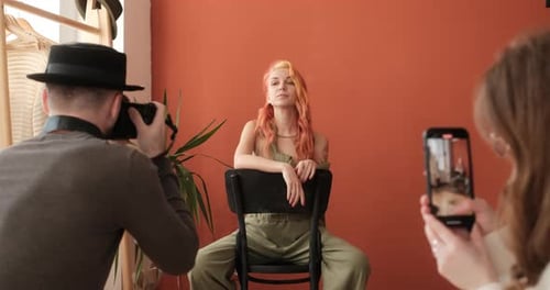 Fashion Model Sitting on Chair in the Studio During Photo Session Assistant Shoots Backstage on