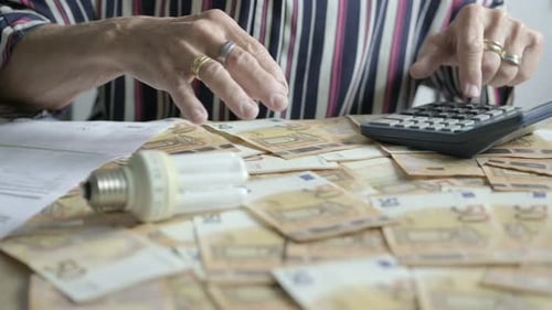 Hands of elder woman calculate ideas and money, euro paper bill home office desk