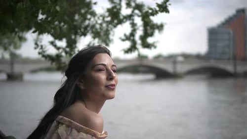 Close Up of an attractive latina tourist looking at river Thames in London, slow motion shot