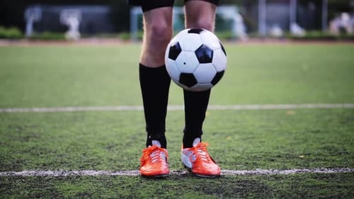Soccer player juggling football with skill on the field in preparation for game day
