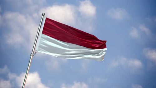 Indonesia Flag Waving on Flagpole Against Cloudy Blue Sky