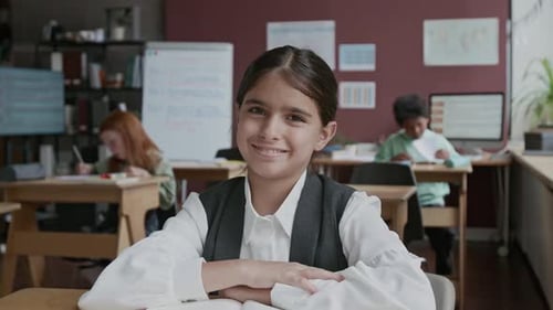 Portrait of Smiling Middle Eastern Girl Sitting at Lesson in Language School