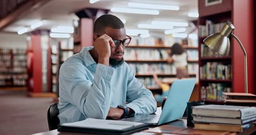 Man, laptop and stress in library for studying research or project deadline for university student