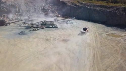 Drohnenaufnahme des Aushubs und Zerkleinerns von Gestein mit schwerem Gerät an einer Felsabbaustelle