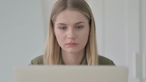 Close Up of Blonde Woman Reacting to Loss on Laptop