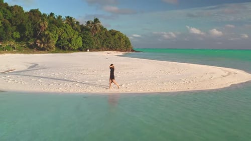 Young Woman Walking on a White Sand Beach in a Tropical Paradise