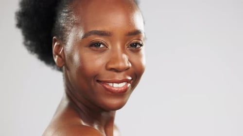 Face, skincare and beauty of black woman laughing in studio isolated on a gray background