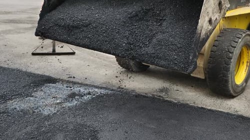 Machine Spreads Asphalt on Pavement for Road Repair
