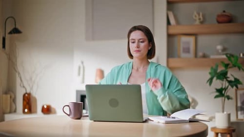 Woman Works at Home and Stretches at Table