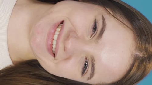 Smiling Woman Close Up Portrait on Blue Background