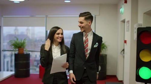 Successful Office Workers Walking Through Workplace Smiling