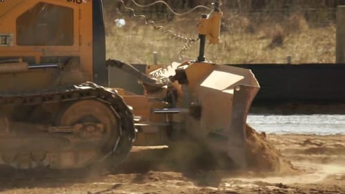 Tractor Moving Red Dirt on a Construction Site