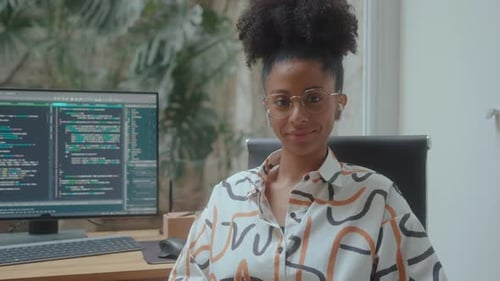 Female Computer Programmer Smiling on Camera at Workplace