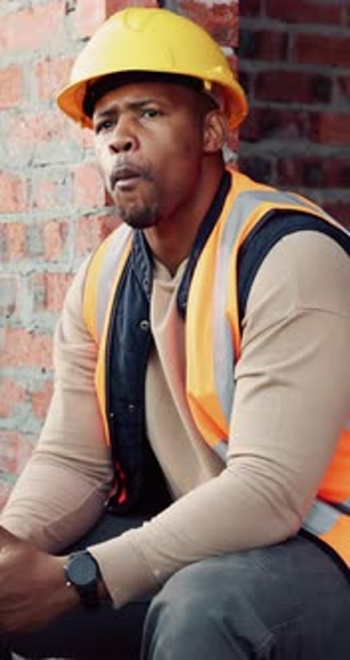 Contractor, man and eating at construction site with break, thinking or planning for renovation