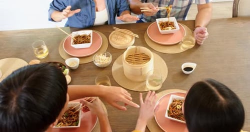 People Share Noodles at a Dining Table