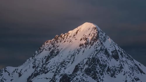 A Majestic SnowCapped Mountain Peak Standing Tall Majestically at Dusk Amid Stunning Colors