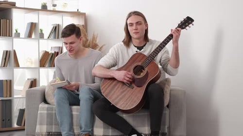 Young Adults Write Song Together on Couch