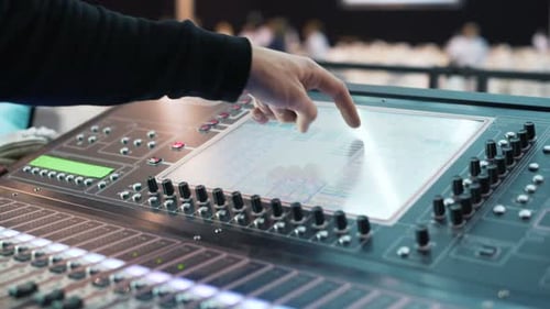 A Man Is Working at an Event. Audio Mixer Knobs Being Pulled