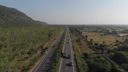 Completely straight highway with medium traffic in rural area of India