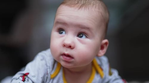 Beautiful Infant Lying on Stomach, Looking Around