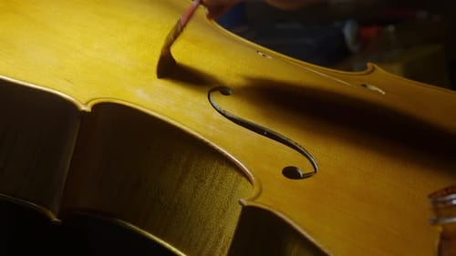 Close-Up of Cello Varnish Application on Top Plate Near F-Holes in Cremona Workshop