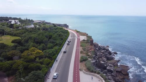Aerial View Of Coastal Road Running Alongside Turquoise Ocean Waves
