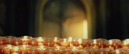 Burning candles in the church. Orthodox cross with crucifixion of Jesus Christ. Christian faith in G